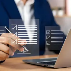 Un homme en costume signe un document numérique, validant un bon à tirer exemple. Des listes de contrôle virtuelles apparaissent sur des écrans transparents.