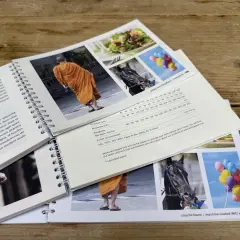 Livre broché : moine en orange, cheval noir, ballons colorés. Spécifications techniques du papier, dont le grammage 200g.