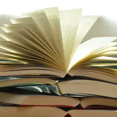 Pile de livres ouverts, pages déployées comme un éventail, évoquant la richesse du savoir et la quête spirituelle. Une maison d'édition spiritualité qui ouvre les portes de la connaissance.