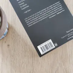 Un ean livre de poésie, "Lait et miel", est posé sur une table en bois, à côté d'une plante succulente.