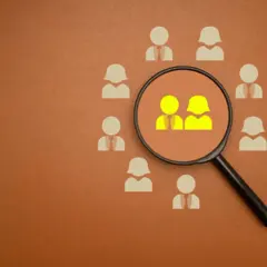Une loupe examine deux silhouettes jaunes parmi d'autres. C'est quoi une maison d'édition ? Elle sélectionne les auteurs et leurs œuvres.