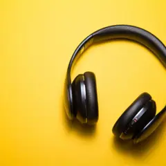 Casque audio noir sur fond jaune, parfait pour écouter un livre audio comment ça marche.