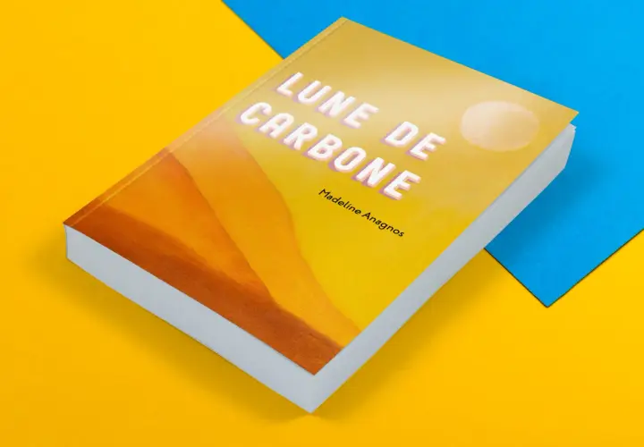 Livre de poche "Lune de Carbone" de Madeline Anagnos, sur fond jaune et bleu. La couverture présente un dégradé orangé et un cercle blanc.