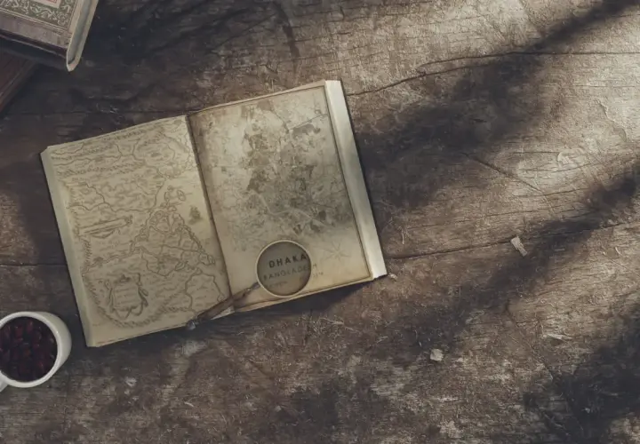 Un livre ouvert avec une carte ancienne, une loupe sur Dhaka, Bangladesh. L'inspiration pour écrire un livre dont vous êtes le héros.