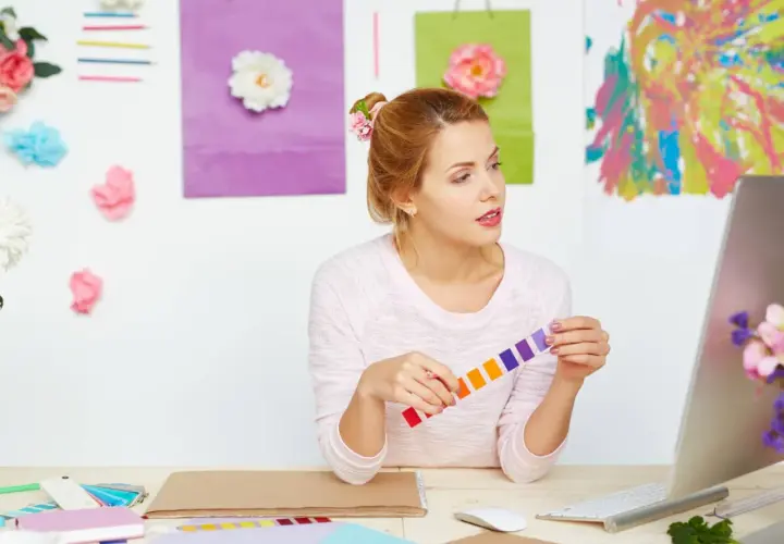 Jeune femme cherchant comment trouver l'inspiration pour écrire, entourée de couleurs vives et de fleurs.
