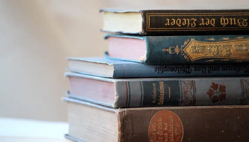 Pile de vieux livres reliés, certains en allemand, évoquant le droit d'auteur livre et le savoir ancien.