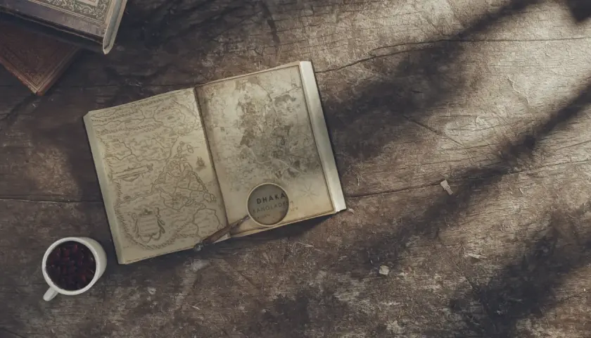 Un livre ouvert avec une carte ancienne, une loupe sur Dhaka, Bangladesh. L'inspiration pour écrire un livre dont vous êtes le héros.