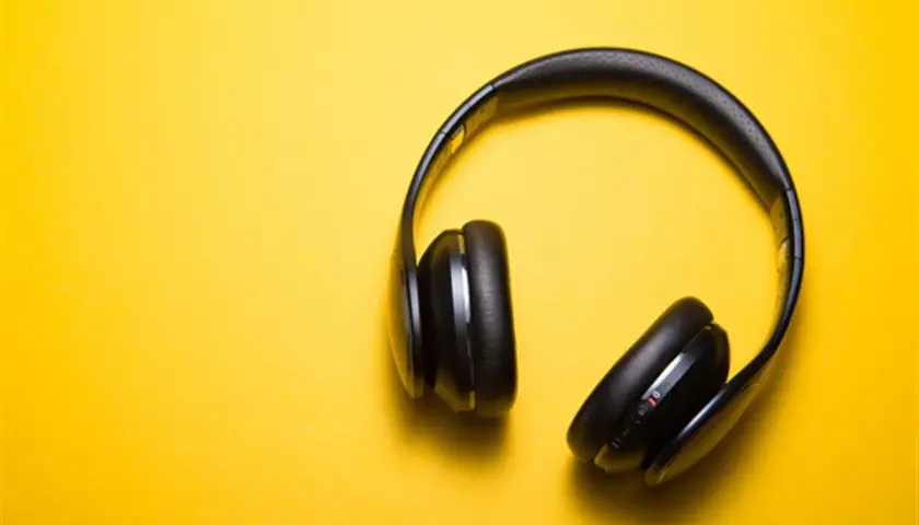 Casque audio noir sur fond jaune, parfait pour écouter un livre audio comment ça marche.