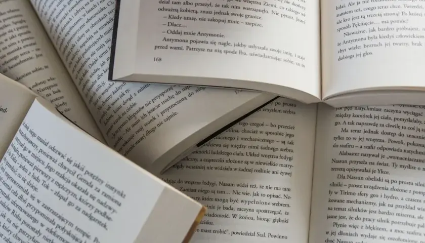 Des livres ouverts, pages remplies de texte, suggèrent la signification de commencer un livre par la fin, une approche narrative intrigante.
