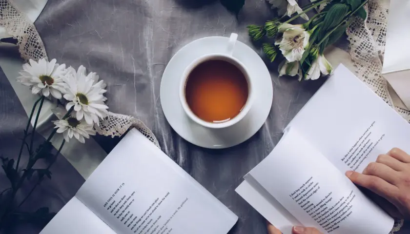 Un thé, des fleurs et un livre ouvert, un moment de calme propice à la réflexion sur le lieu d'édition d'un livre.