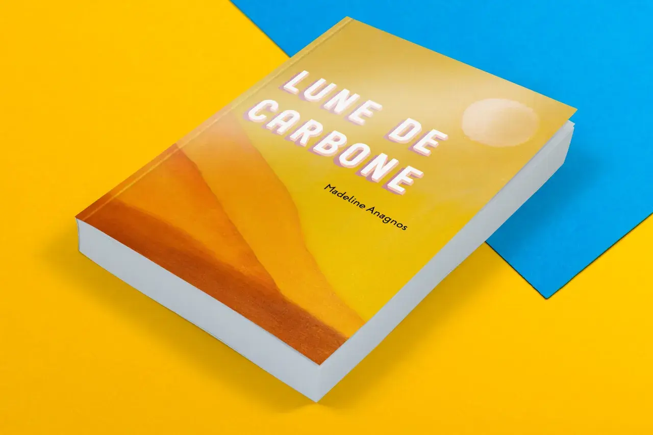 Livre de poche "Lune de Carbone" de Madeline Anagnos, sur fond jaune et bleu. La couverture présente un dégradé orangé et un cercle blanc.