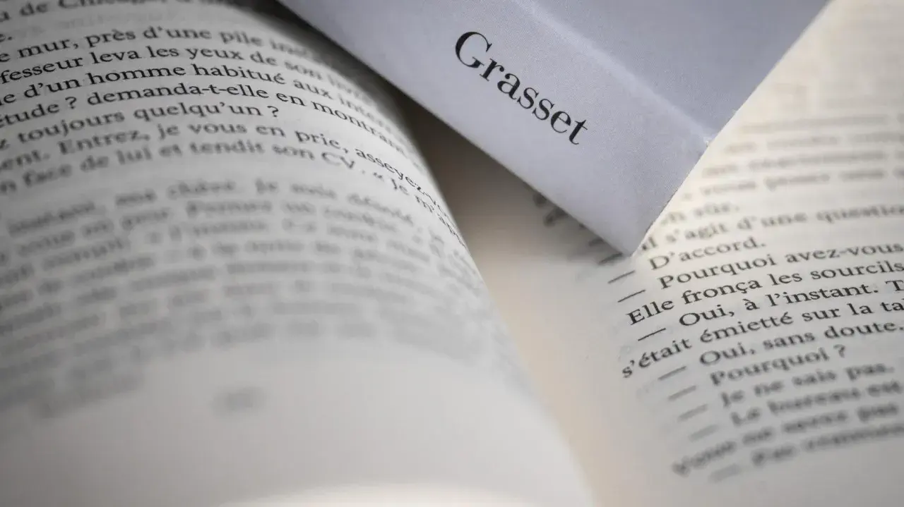 Pages ouvertes d'un livre, avec le nom "Grasset" visible sur une couverture. Un aperçu de la ligne éditoriale de cette maison d'édition.