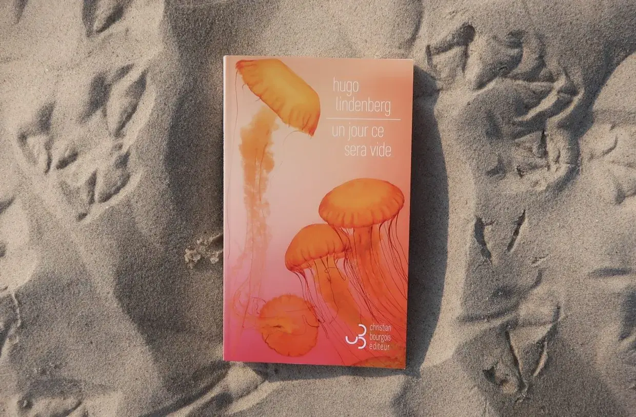 Livre "Un jour ce sera vide" de Hugo Lindenberg sur le sable, avec des traces d'oiseaux. Une méditation sur le temps qui passe.