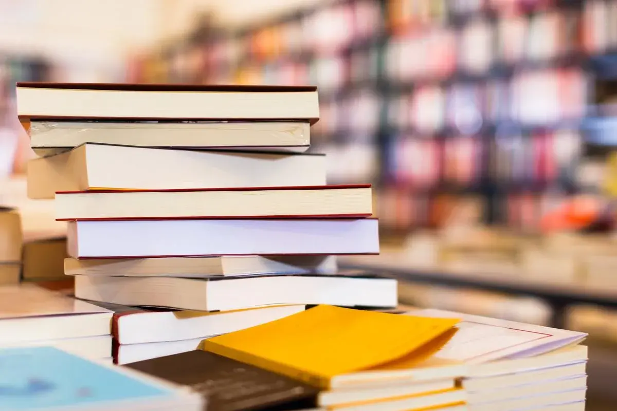 Une pile de livres, certains ouverts, d'autres fermés, évoque une **antanaclase** : chaque livre est une porte vers un monde, et chaque monde est une nouvelle lecture.