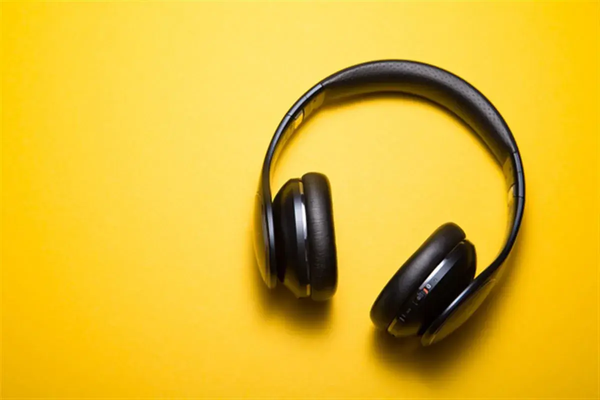 Casque audio noir sur fond jaune, parfait pour écouter un livre audio comment ça marche.