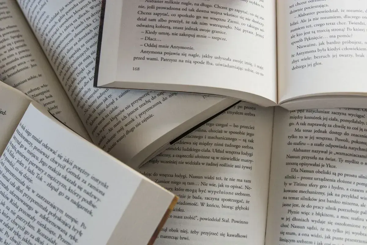 Des livres ouverts, pages remplies de texte, suggèrent la signification de commencer un livre par la fin, une approche narrative intrigante.