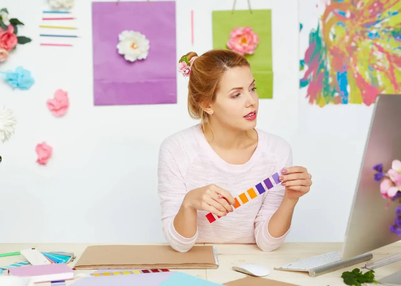 Jeune femme cherchant comment trouver l'inspiration pour écrire, entourée de couleurs vives et de fleurs.