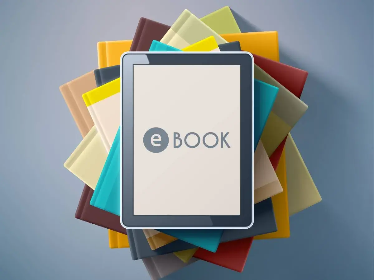 Une tablette affiche "e BOOK" au milieu d'une pile de livres colorés.