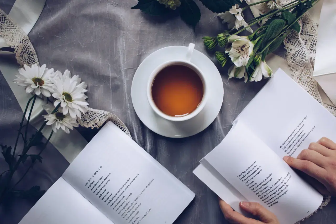 Un thé, des fleurs et un livre ouvert, un moment de calme propice à la réflexion sur le lieu d'édition d'un livre.
