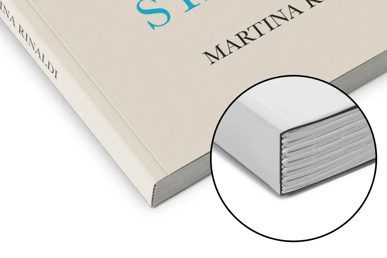 Gros plan sur un livre reli&eacute;, pr&ecirc;t &agrave; imprimer son roman. La tranche des pages est visible, montrant la qualit&eacute; de la reliure.