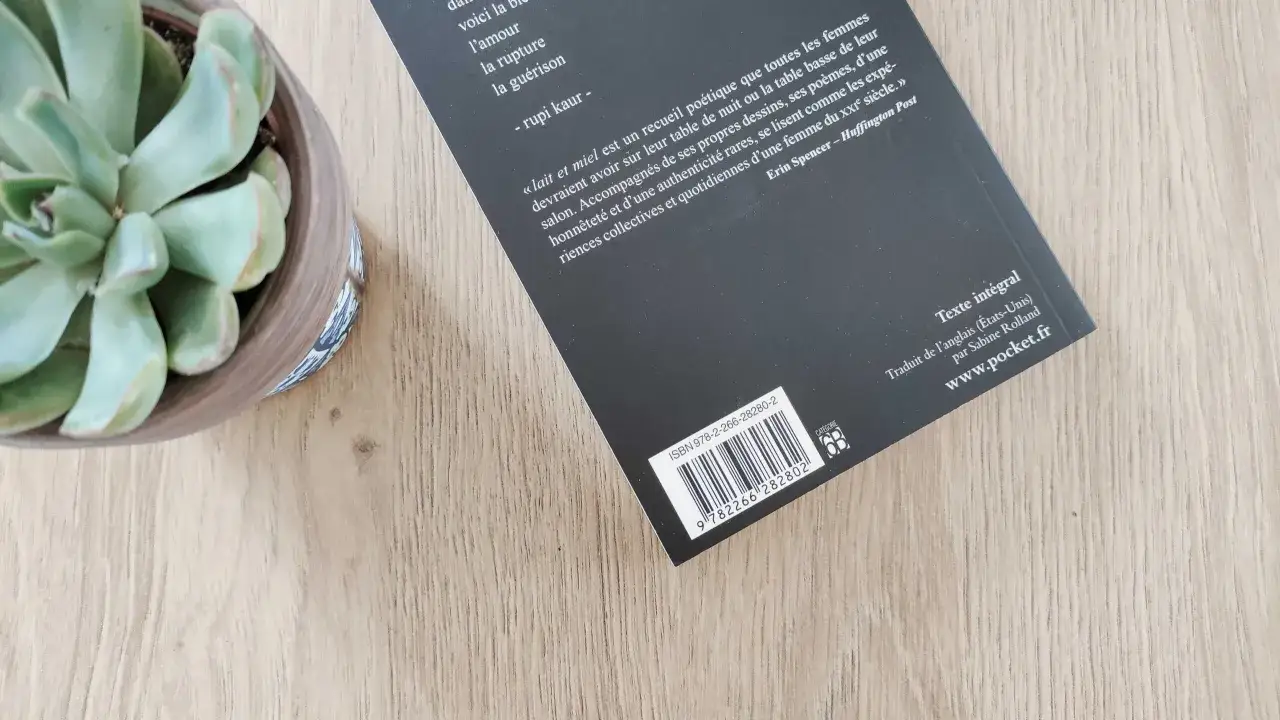 Un livre de poésie avec un code ISBN et EAN visible, à côté d'une plante succulente.