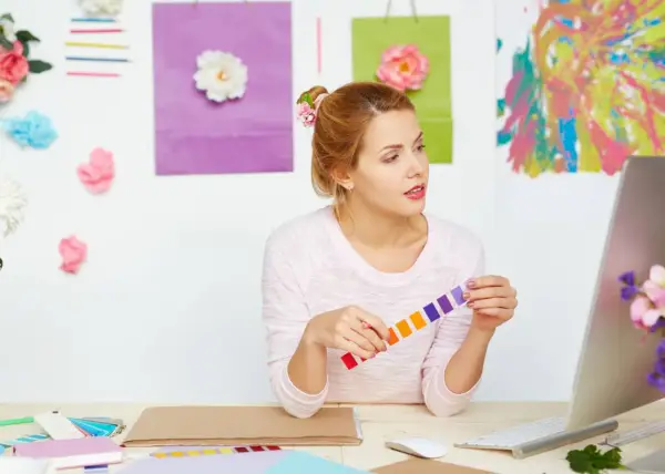 Jeune femme cherchant comment trouver l'inspiration pour écrire, entourée de couleurs vives et de fleurs.